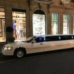 Limousine a noleggio a milano che passa davanti ai negozi di marche famose